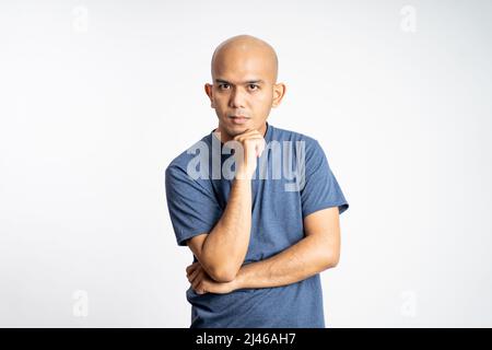 amazed asian bald man with hands holding mouth standing Stock Photo