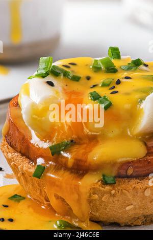 Close up of tasty egg benedict with poached egg, ham and hollandaise sauce. close up. vertical orientation. English brunch Stock Photo