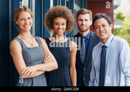 Stepping outside with the team for some fresh air. Portrait of a group of happy young professionals standing together outside. Stock Photo
