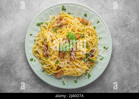 Pasta spaghetti carbonara with pancetta, bacon, egg, parmesan cheese and cream sauce on gray table. Italian food. top view Stock Photo