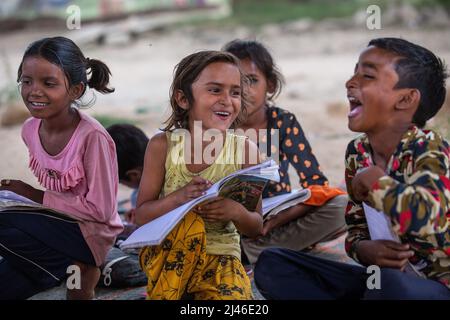 New Delhi, India. 12th Apr, 2022. Children study in a makeshift school under a metro bridge in New Delhi, India, April 12, 2022. The free school underneath the metro bridge is run by a group of undergraduate students for children who come from the slums situated adjacent to the Yamuna river. Credit: Javed Dar/Xinhua/Alamy Live News Stock Photo