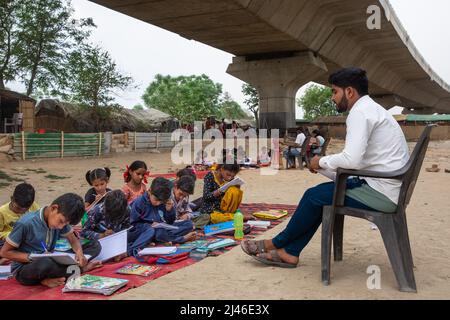 New Delhi, India. 12th Apr, 2022. Children study in a makeshift school under a metro bridge in New Delhi, India, April 12, 2022. The free school underneath the metro bridge is run by a group of undergraduate students for children who come from the slums situated adjacent to the Yamuna river. Credit: Javed Dar/Xinhua/Alamy Live News Stock Photo