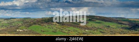 Long-distance picturesque sunny panorama (hillside woodland, green fields, tv radio mast tower, cloudy sky) - Washburn Valley, Yorkshire, England, UK. Stock Photo