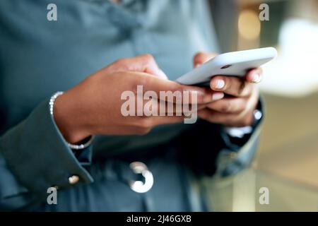Take a dive into the digital world. Shot of an unrecognizable businesswoman using a phone at work. Stock Photo