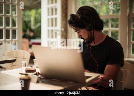 Man working with his notebook on a cafe Stock Photo