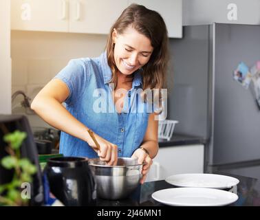 A healthy outside starts from the inside. Shot of a young female preparing a meal at home. Stock Photo