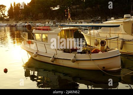 Mandre, Croatia, 26th Mart, 2022. A vintage fishing boat moored on the pier in the village harbor during late evening at dusk Stock Photo