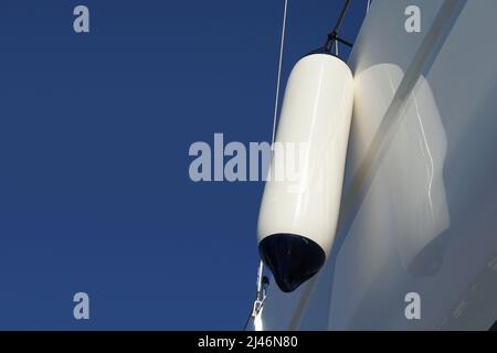 Side fender on a yacht on a dry dock outside the sea with blue free space for copy Stock Photo