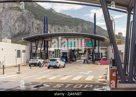 GIBRALTAR, UK - APRIL 7, 2022 - Cars and pedestrians cross the runway of Gibraltar airport at the border of Spain to enter Gibraltar. Stock Photo