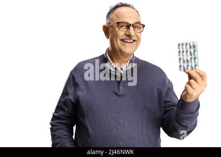 Mature man holding a pack of pills and smiling isolated on white background Stock Photo