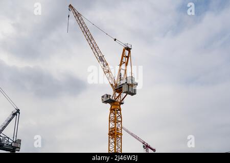 A huge Züblin construction crane high up in the sky. Technology at a construction site to lift heavy materials. Professional equipment Stock Photo