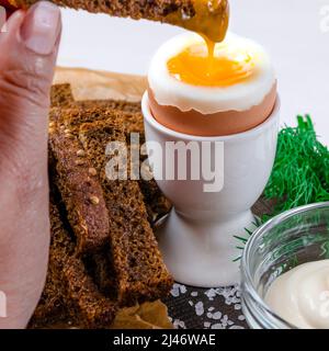 English breakfast with boiled egg and croutons on a white wood background Stock Photo
