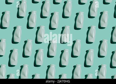 Modern seamless pattern flat lay shot of white plastic bottles on bluish green background, conscious consumption and plastic waste concept Stock Photo