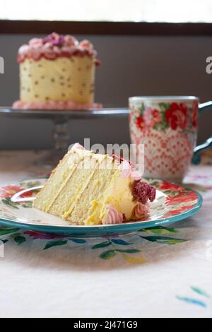 A slice of vanilla cake in a plate, with dried fruit, and dried flowers with a fork. Stock Photo