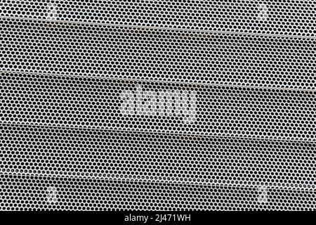 Background of wavy metallic grid with holes. Metal mesh as background. Perforated metal back. Stock Photo