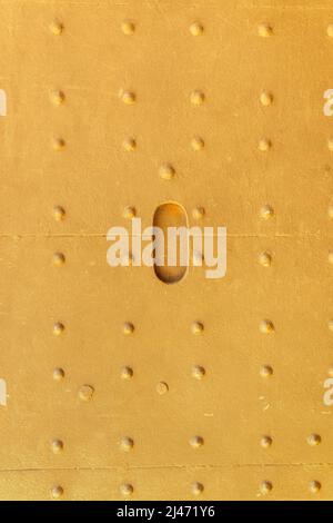 Metal texture with rows of rivets painted yellow. Bright and light background. Stock Photo