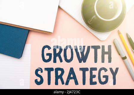 Conceptual caption Growth Strategy. Word Written on Strategy aimed at winning larger market share in shortterm Office Supplies Over Desk With Keyboard Stock Photo