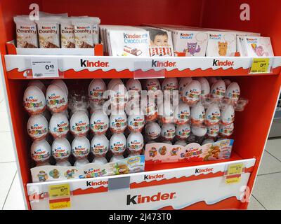 Kinder Surprise chocolate eggs and other Kinder Easter products on display in supermarket. Kinder chocolate by Ferrero company. Stock Photo
