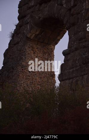 Photos taken at sunset while on a stroll through the beautiful Aqueducts Park in Rome, with the majestic ruins of ancient Roman aqueducts and trees Stock Photo