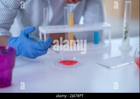 Close up of a person in a lab coat working with reagents Stock Photo
