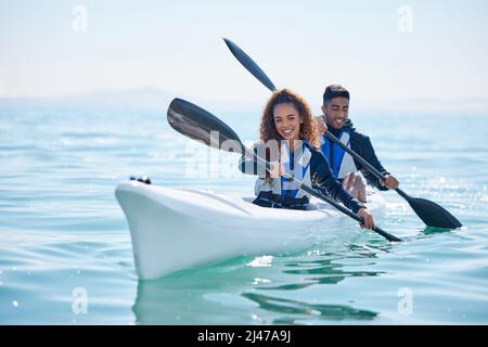 We row together, we grow together. Portrait of a young couple kayaking together at a lake. Stock Photo