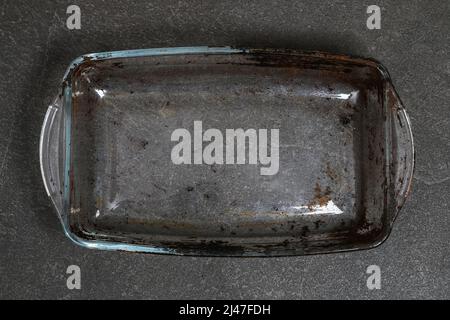 Dirty baking dish with a thick layer of carbon. Glassware for baking with soot, carbon deposits, old dried fat. Stock Photo