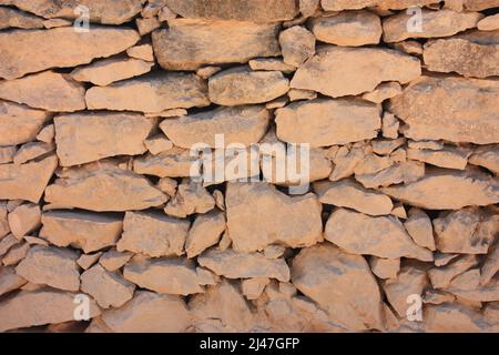 orange and red dry stone wall set with dust from earth and sand Stock Photo