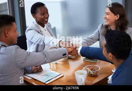 None of us is as smart as all of us. Shot of a group of colleagues having a meeting and breakfast in a modern office. Stock Photo