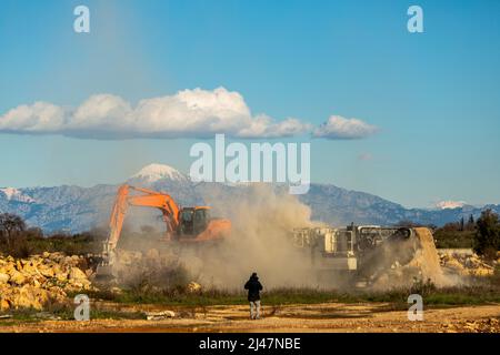 Stone filled crusher with stone crusher and bucket Stock Photo