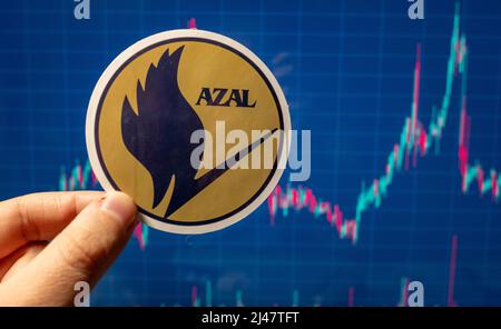 November 10, 2021, Baku, Azerbaijan. The emblem of Azerbaijan Airlines against the background of a share price chart. Stock Photo