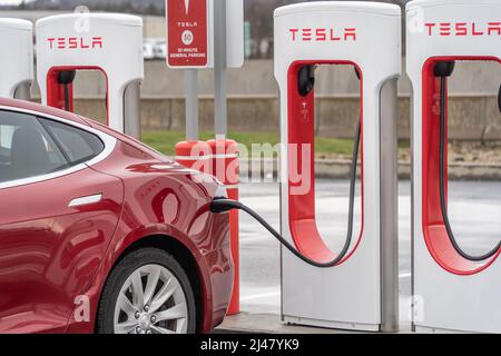 North Somerset, Pennsylvania-April 8, 2022: A car charging at the Tesla Electric Super Charger Station at North Somerset Service Plaza on the Pennsylv Stock Photo