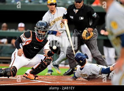Baltimore, United States. 12th Apr, 2022. Milwaukee Brewers' Christian Yelich (22) scores past Baltimore Orioles catcher Robinson Chirinos (L) as Brewers' Willy Adames (27) looks on during the first inning of a game at Camden Yards in Baltimore, MD, on Tuesday, April 12, 2022. Photo by David Tulis/UPI Credit: UPI/Alamy Live News Stock Photo
