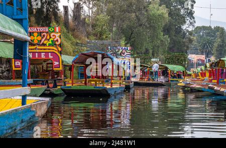 MEXICO CITY - Dec 19, 2021. Colorful boats parked on a canal in Xochimilco Floating Gardens of Mexico. Stock Photo