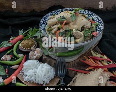 Green curry with Chicken and Green-white varieties of Thai eggplants (Kaeng khiao wan) in Ceramic bowl served with Thai rice noodles (Fermented rice f Stock Photo