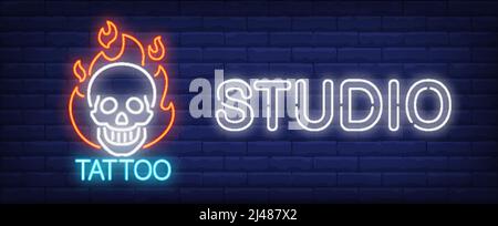 Tattoo studio neon sign. Smiling scull on fire and big inscription on dark brick wall. Vector illustration in neon style for tattoo salon or luminous Stock Vector