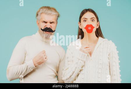 Photo booth concept. Couple having fun with with fake mustache and lips. Stock Photo