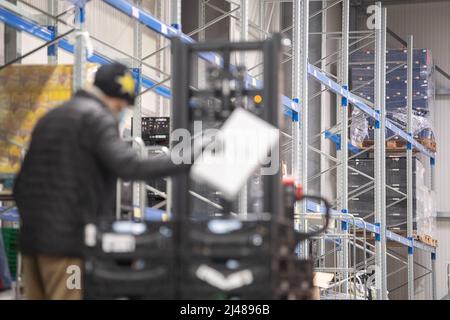 12 April 2022, Hessen, Frankfurt/Main: An employee works in the Tafel Frankfurt warehouse in front of an empty high rack. The Tafel in Frankfurt is currently struggling with the fact that it is receiving fewer donations in the face of higher demand. Photo: Sebastian Gollnow/dpa Stock Photo