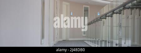 Empty corridor with doors to rooms in hotel building Stock Photo