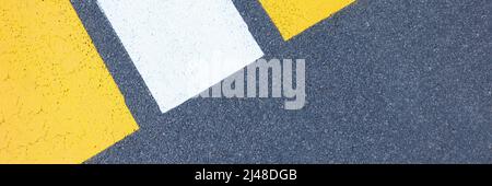 Closeup of yellow and white stripes on gray asphalt background Stock Photo