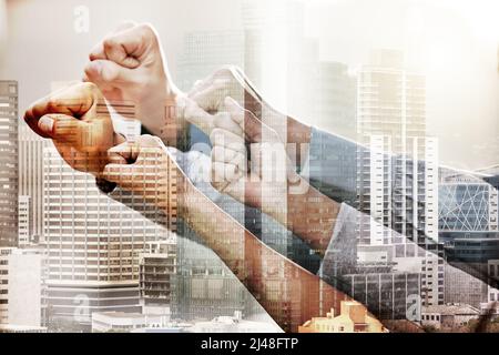 Success is a team effort. Shot of a group of unrecognizable businesspeople holding their fists up in solidarity. Stock Photo