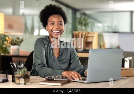 Its about putting in the work. Cropped portrait of an attractive young businesswoman working on her laptop in the office. Stock Photo