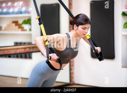 Young sportswoman doing the upper body workout Stock Photo by Iakobchuk