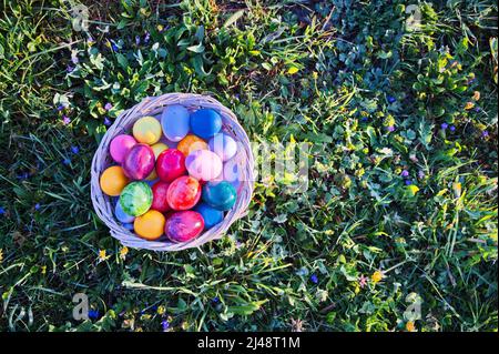 Directly above shot of Easter eggs in wicker basket on green meadow Stock Photo