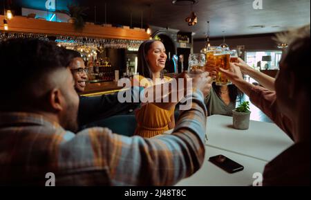 diverse group of friends out for beers making a toast  Stock Photo