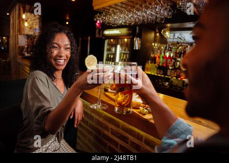 two friends having drinks at the bar cheers  Stock Photo