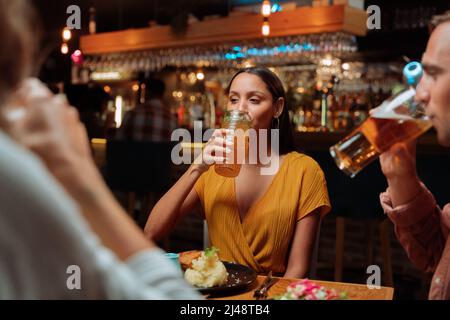 diverse group of friends out for dinner drinking cocktails Stock Photo