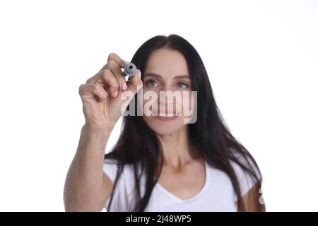 Smiling woman holding marker and writing something in air Stock Photo