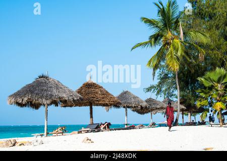 Zanzibar, Tanzania - April 22,2022:: Masai warriors dressed in traditional clothes on sand beach of Zanzibar island. Stock Photo