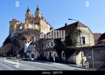 Melk, Austria - March 26, 2022: Impressive baroque Melk abbey on rock and building with former post office in UNESCO world heritage site of Danube Val Stock Photo