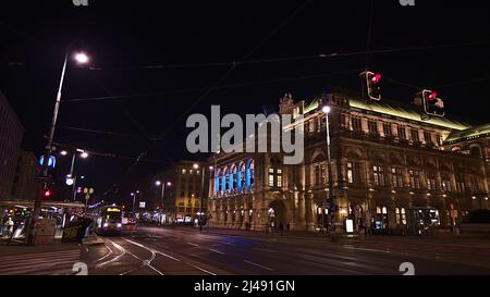 Beautiful view of the illuminated facade of the Vienna State Opera building in Austria by night with tram in front. Stock Photo